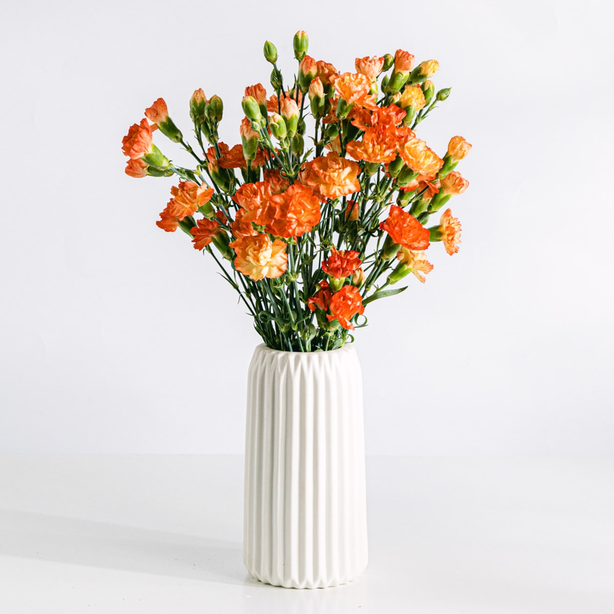 Ramo de flores de claveles naranja con jarrón