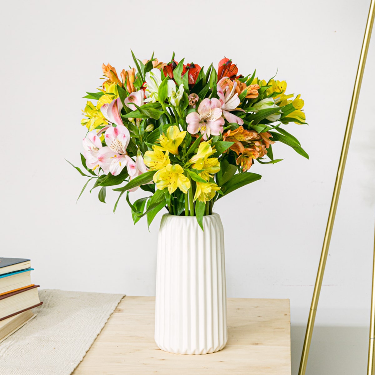 Bouquet di fiori di alstroemeria rosa, rossa, gialla e arancione, pianta di cera bianca, iperico ed eucalipto