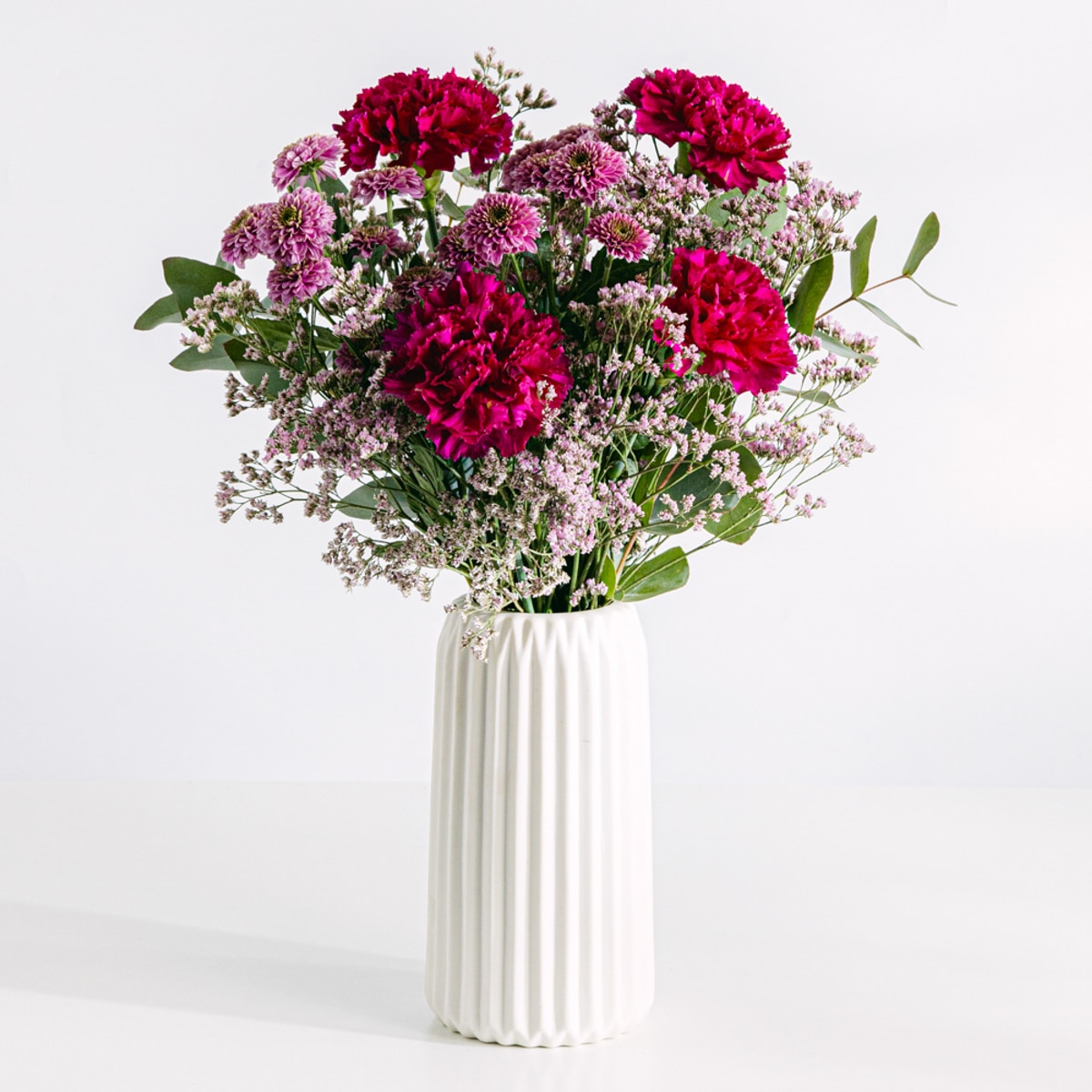 Flower bouquet of purple carnations and pink chrysanthemums with vase
