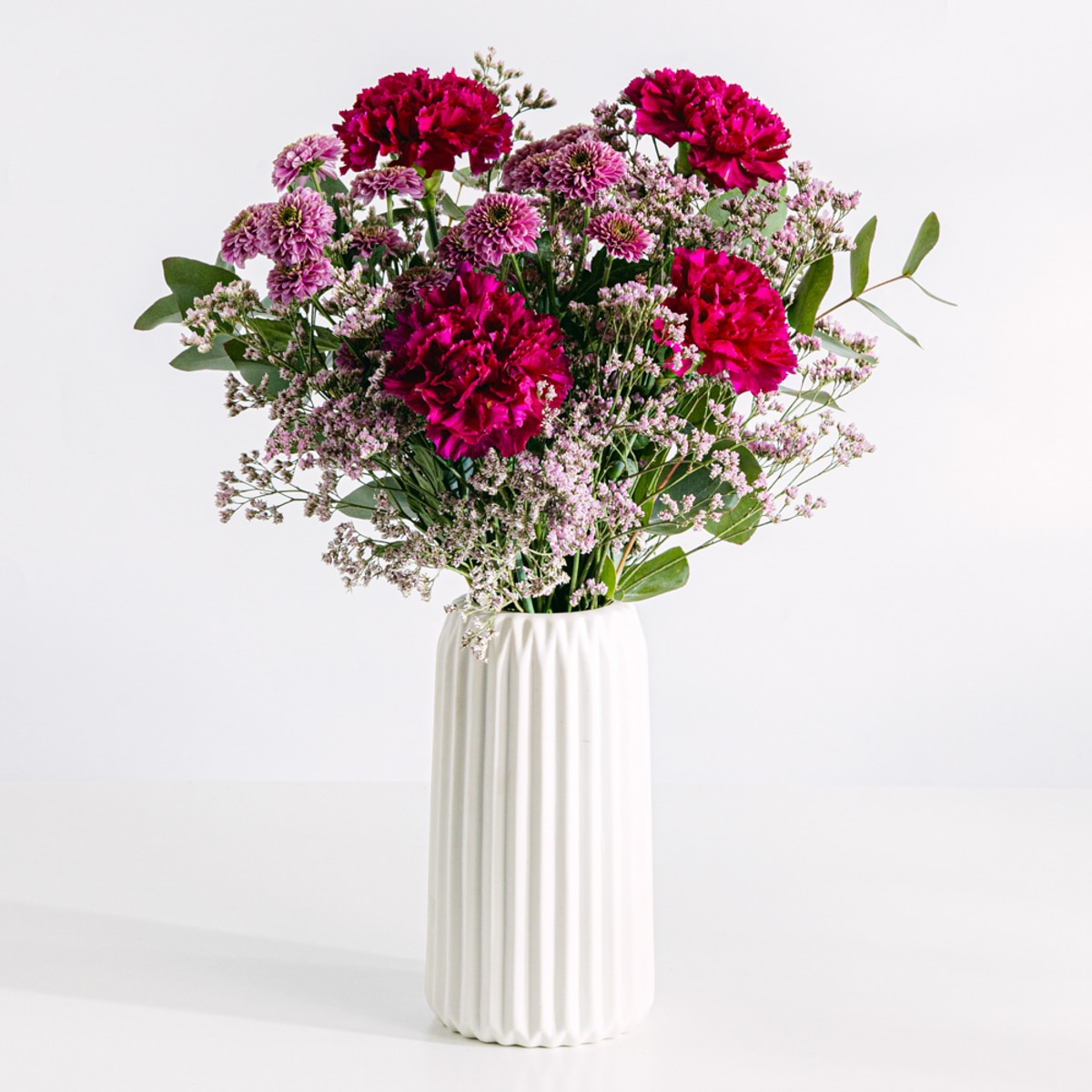 Blumenstrauß aus lila Nelken und rosa Chrysanthemen mit Vase