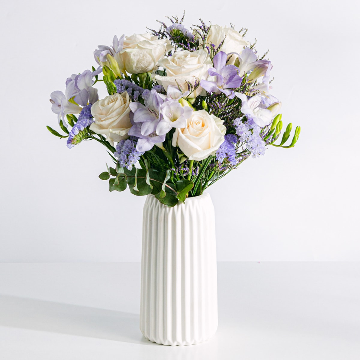 Bouquet de rosas brancas com frésias e limonium em vaso