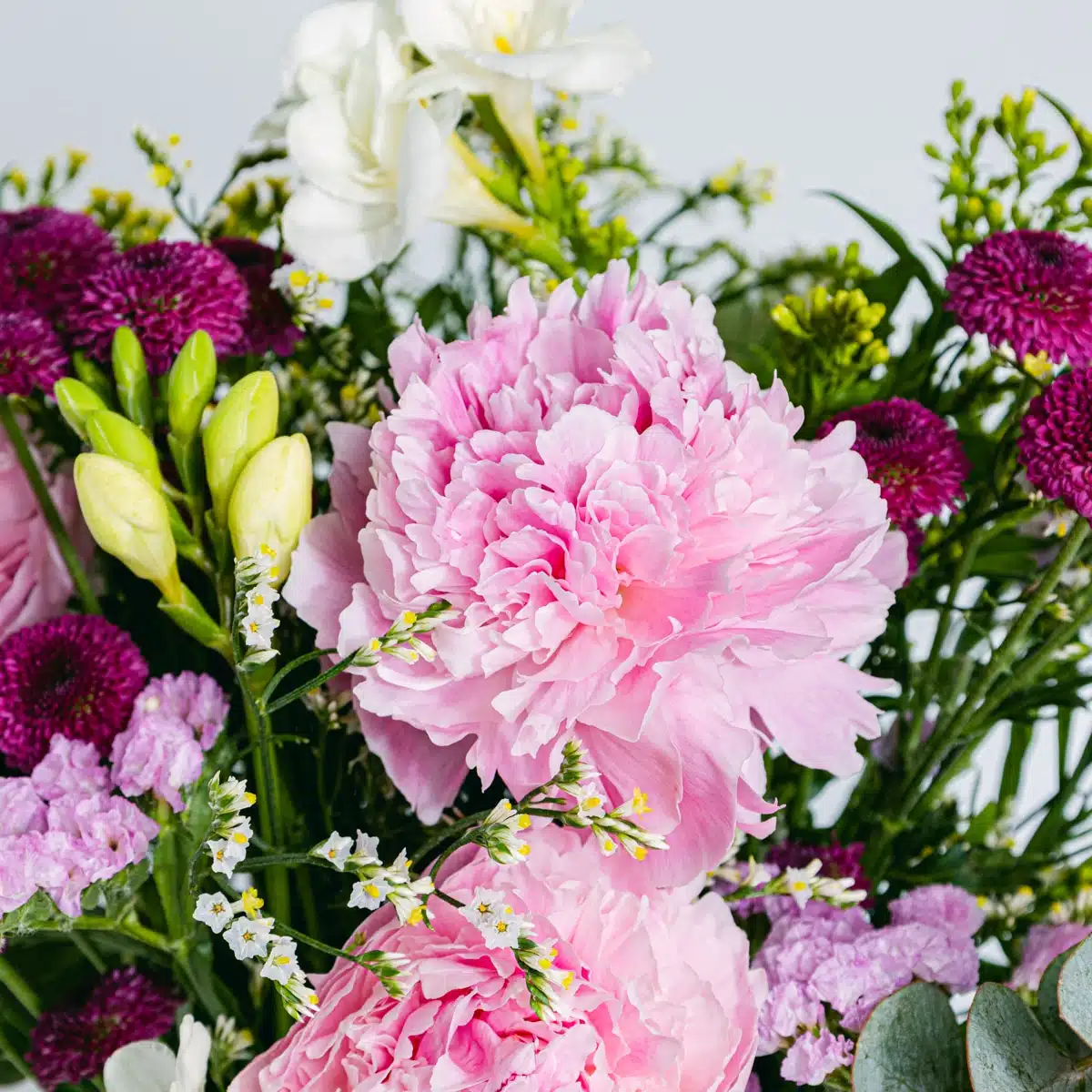 Details from close-up of bouquet of pink peonies and pink freesias